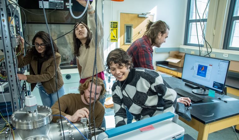 Five students working in lab together